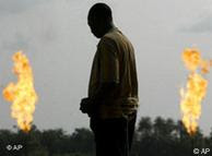 An unidentified man stands near a gas flare belonging to the Agip Oil company in Idu Ogba, Niger Delta area of Nigeria