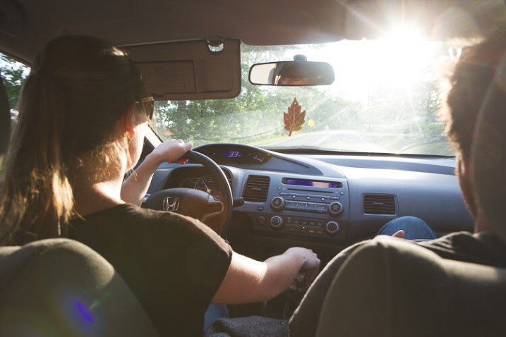 A warm, summery picture of a couple driving a car - capture the mood and atmosphere of the shot.