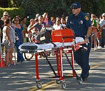 Un sanitario traslada a un joven que se desmayó ante la casa de Jackson. | AP