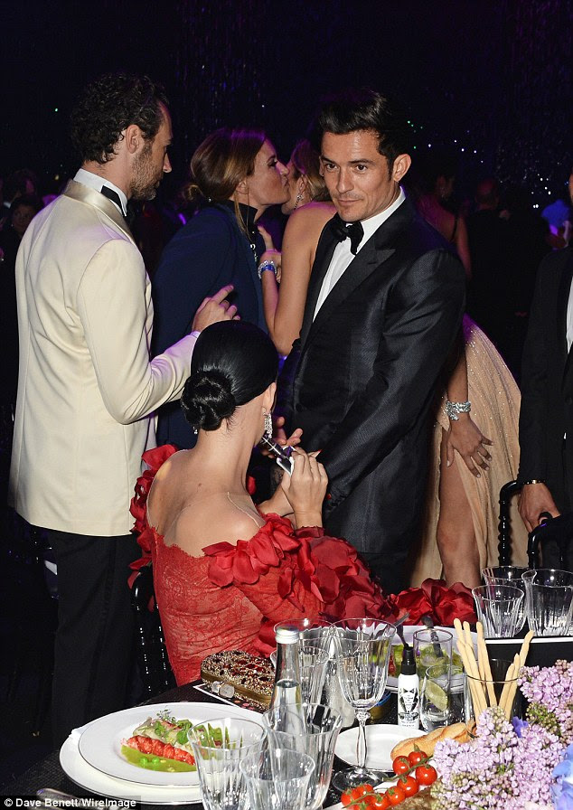 Dinner date: Katy rested her feet as she grabbed a bite to eat whilst Orlando watched over her
