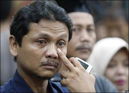Seorang pria menitikkan air mata ketika konvoi duka mendiang Suharto melintas