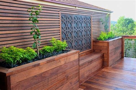 The many bright colors of greenbo . Merbau decking with a custom made screen, planters and