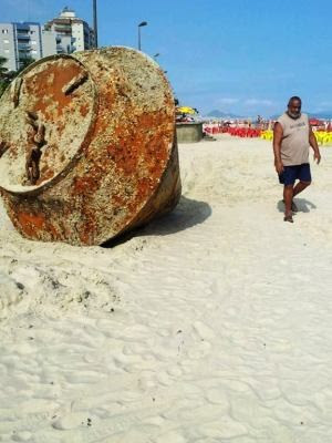Curiosos tentam identificar objeto que surgiu nas areias de Praia Grande, SP. (Foto: Andressa Amorim/G1)