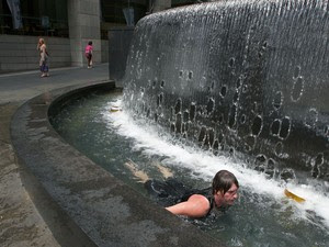 Morador de Sidney, na Austrália, mergulha em uma fonte da cidade para se refrescar, em dia que a temperatura local chegou a 42 graus. Em outras regiões do país, a previsão é de que o calor passe de 45 graus. (Foto: Rick Rycroft/Reuters)