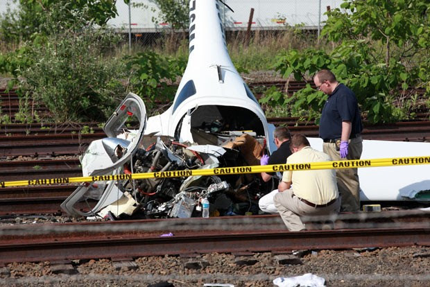 Investigadores observam destroços do avião nesta sexta-feira (31) em Linden, Nova Jersey (Foto: David Karp/AP)