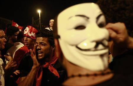 An anti-government protester wears a Guy Fawkes mask as another shouts slogans during a demonstration in Tunis August 6, 2013. REUTERS/Anis Mili