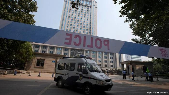 A police van drives past the Jinan Intermediate People