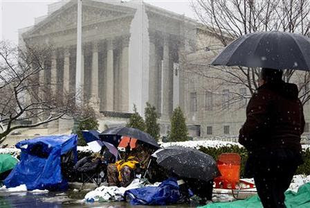 People, who have been waiting for days in winter weather to witness historic cases against anti-gay marriage statutes, are seen on the sidewalk in front of the Supreme Court building in Washington, March 25, 2013. REUTERS/Jonathan Ernst
