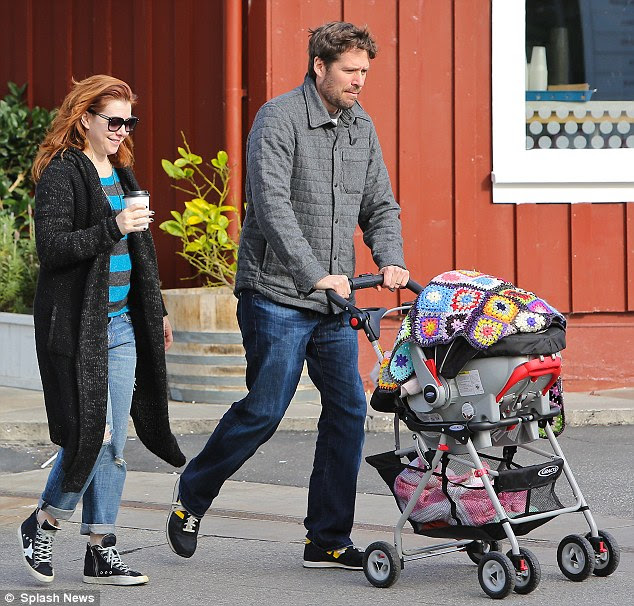 Doting dad: Her husband Alexis, who turns 47 next month, gave passerbys but a glimpse of their precious eight-month-old resting comfortably in her stroller