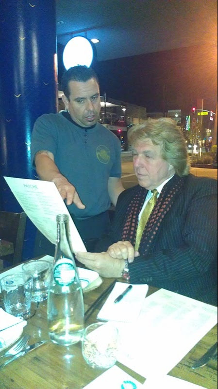 Pete Allman looks over the menu with a well versed waitor