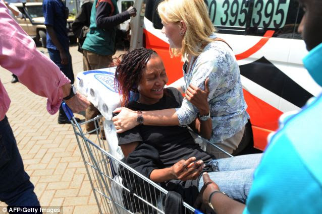 Rescue: A woman is shipped to an ambulance in a shopping trolley by centre staff