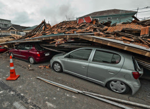 A collapsed building crushes parked cars after a high-intensity earthquake hit Christchurch, February 22, 2011