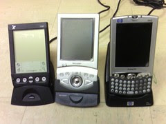 Three PDAs in cradles