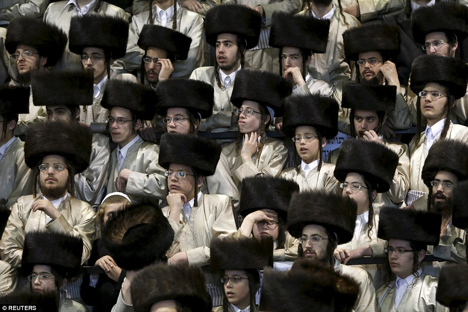 The Jewish men attend the wedding in traditional shtreimel hats as they watch the proceedings