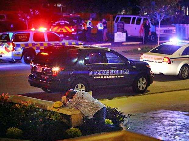 Um homem se ajoelha em frente a igreja atacada (Foto: Wade Spees / The Post e Courier / via AP Photo)