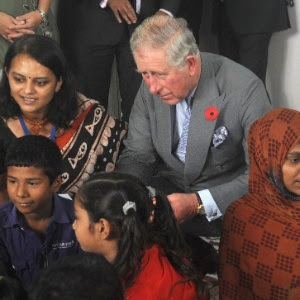 O príncipe britânico Charles (segundo à esq.) e sua mulher, Camilla (terceira à dir.), cumprimentam crianças indianas durante visita a uma creche em Mumbai