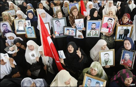 Palestinian women hold photos of relatives held in Israeli prisons as they call for their release.