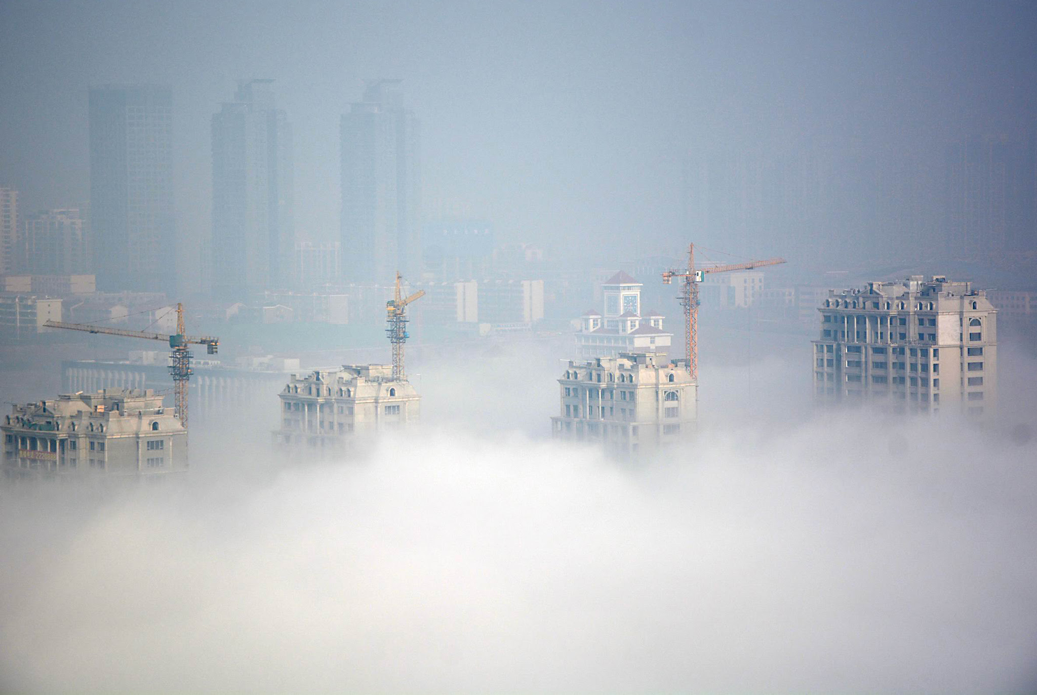 Buildings under construction are seen during a hazy day in Rizhao...Buildings under construction are seen during a hazy day in Rizhao, Shandong Province, China, March 15, 2016. REUTERS/Stringer ATTENTION EDITORS - THIS PICTURE WAS PROVIDED BY A THIRD PARTY. THIS PICTURE IS DISTRIBUTED EXACTLY AS RECEIVED BY REUTERS, AS A SERVICE TO CLIENTS. CHINA OUT. NO COMMERCIAL OR EDITORIAL SALES IN CHINA.       TPX IMAGES OF THE DAY