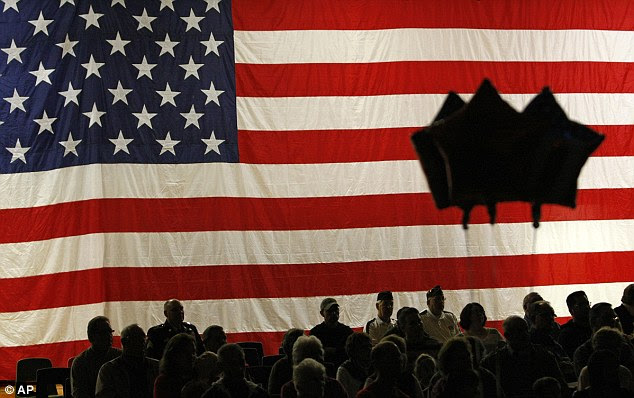 Nation's pride: Veterans and their families are silhouetted as they watch a Veterans Day program at Southwestern High School in Hazel Green, Wisconsin