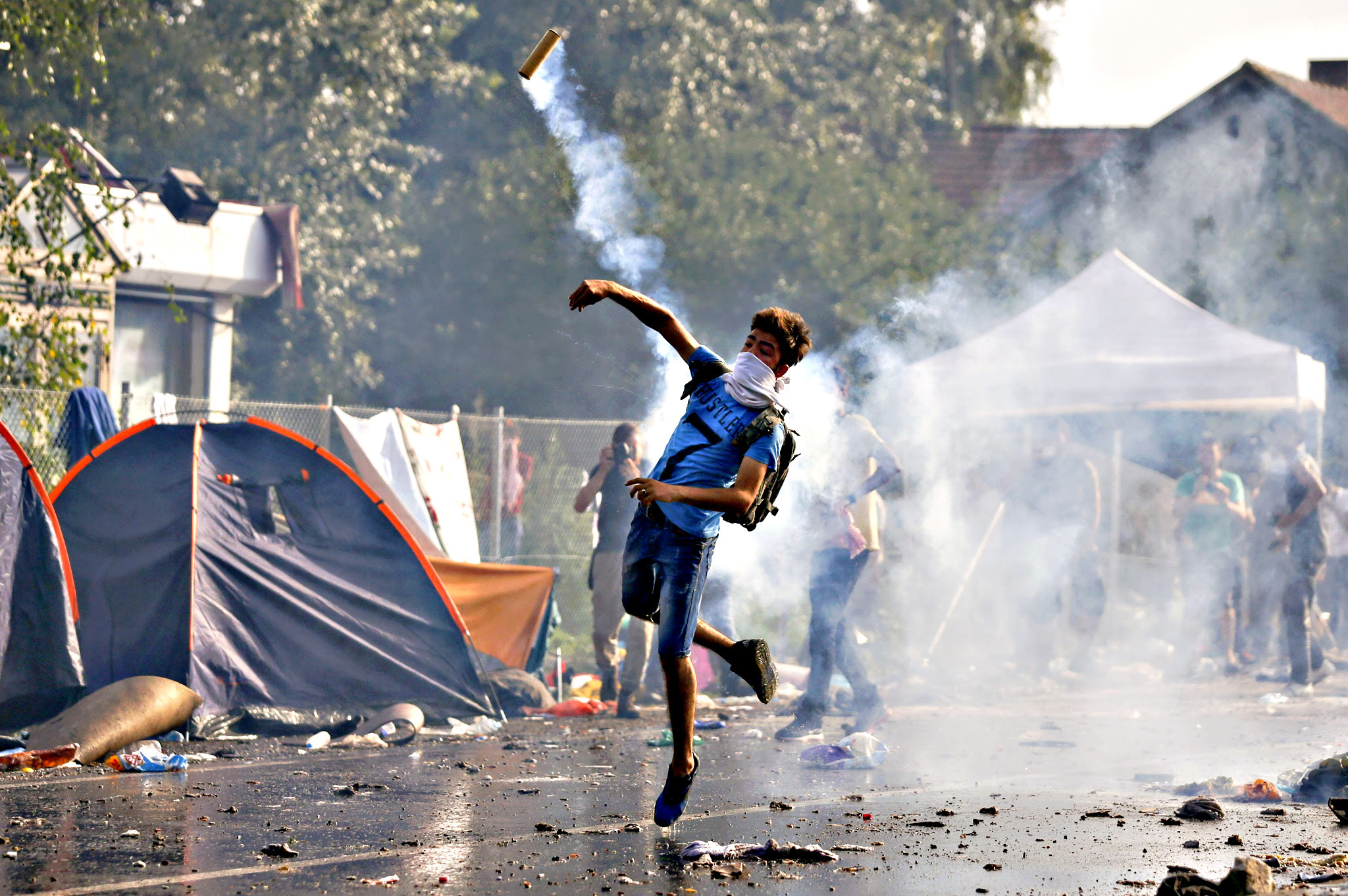 A migrant protests as Hungarian riot police fires tear gas and water cannon at the border crossing with Serbia in Roszke...A migrant protests as Hungarian riot police fires tear gas and water cannon at the border crossing with Serbia in Roszke, Hungary September 16, 2015. Hungarian police fired tear gas and water cannon at protesting migrants demanding they be allowed to enter from Serbia on Wednesday on the second day of a border crackdown