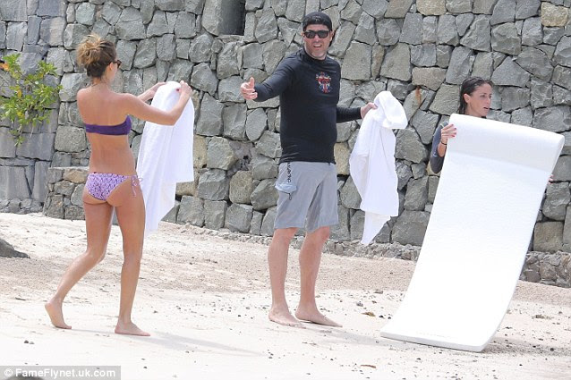 Helping hand: Alba offered a towel to a friend during the getaway 