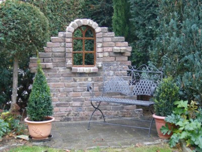 Ruinenmauer als optischer Blickfang im Garten