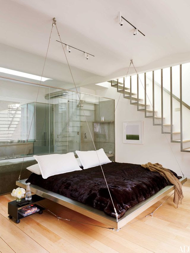 In the master bedroom of investor Yoon Kim’s Manhattan bachelor pad, which was designed by David Mann and Brett McMullen of MR Architecture + Décor, the floating bed by Robert Bernstein is dressed in Calvin Klein linens, a mink coverlet by ER Fur Trading, and a throw from ABC Carpet & Home. The photograph displayed on the wall is by Dietmar Busse.