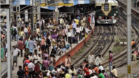 Passengers wait at a railway station in Delhi, India (31 July 2012)