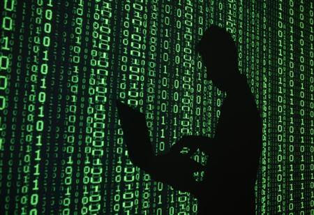An illustration picture shows a projection of binary code around the shadow of a man holding a laptop computer in an office in Warsaw June 24, 2013. REUTERS/Kacper Pempel