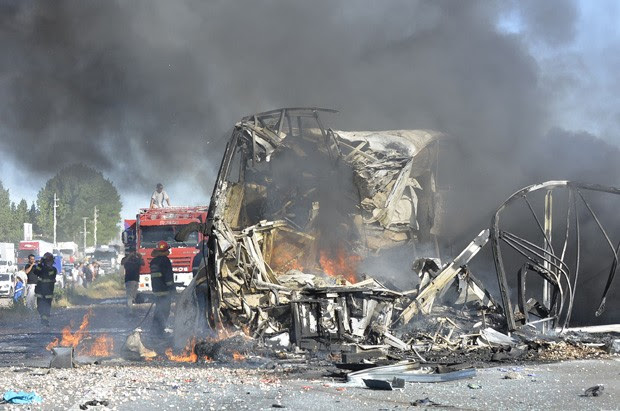 Bombeiros apagam as chamas de ônibus de passageiros que colidiu com caminhão na Argentina, deixando 17 mortos (Foto: Los Andes/Ap)
