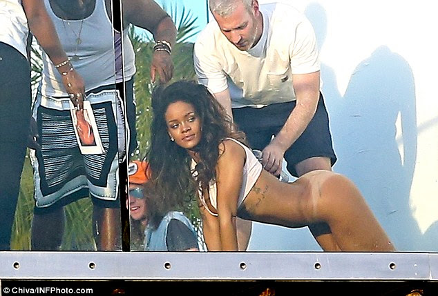 Bottoms up: Rihanna got half-naked for a steamy photo shoot on a residential balcony in West Hollywood, California on Wednesday