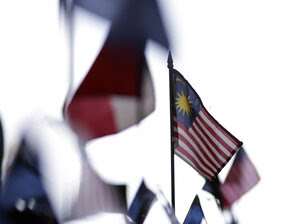 A Malaysian flag sits on a table among other flags during a news conference at the Trans-Pacific Partnership Free Trade Agreement talks in July 2012 in San Diego. Nearly two and a half years later, the deal remains incomplete.