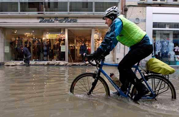 A man cycles through a flooded street in Geraardsbergen, Belgium, on Sunday.