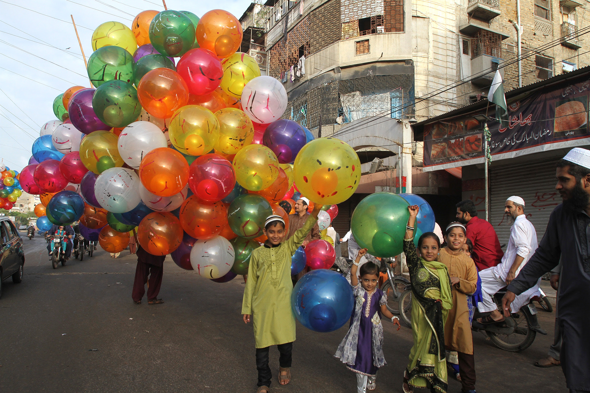 Pakistani children buy balloons to celebrate the Eid al Adha in Karachi, Pakistan, Tuesday, Sept. 13, 2016. Pakistani Muslims are celebrating the Eid al-Adha, or the Feast of the Sacrifice, on Tuesday to mark the willingness of the Prophet Ibrahim -- Abraham to Christians and Jews -- to sacrifice his son. During the holiday Muslims slaughter sheep and cattle, distribute part of the meat to the poor and eat the rest. (AP Photo/Fareed Khan)