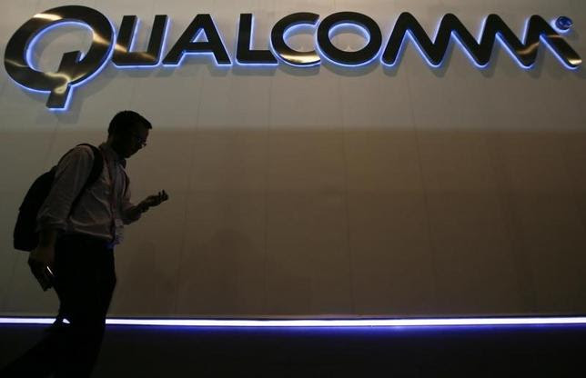 A man walks past Qualcomm stand while attending the Mobile World Congress in Barcelona March 3, 2015. REUTERS/Albert Gea