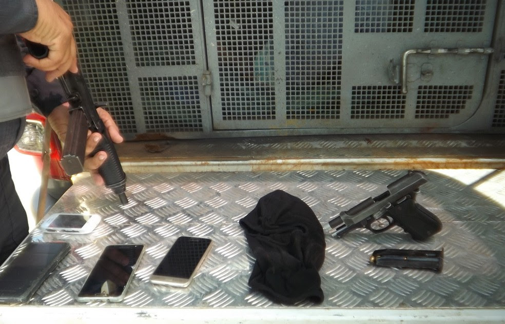 Pistola, munições, capuz e celulares foram apreendidos com os suspeitos (Foto: Divulgação / PM)