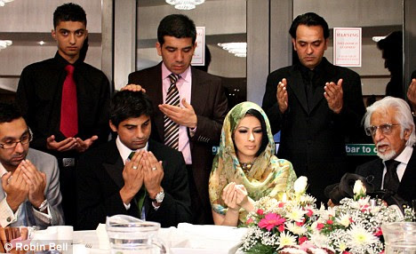 The couple surrounded by family members during their wedding ceremony