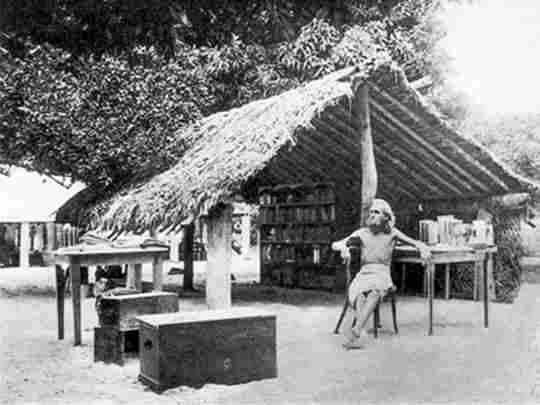 German nudist August Engelhardt sits in front of his thatched tent-like hut on the island of Kabakon (in what is now Papua New Guinea) with the books that he brought with him from Germany. In 1902, he moved to the South Pacific to start a utopian cult that revolved around two orbs: the coconut and the sun.