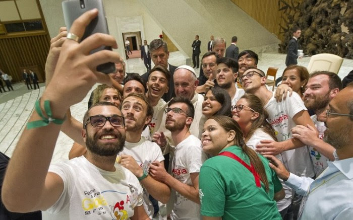 Pope Francis, center, poses for a selfie this month in Rome (PA)