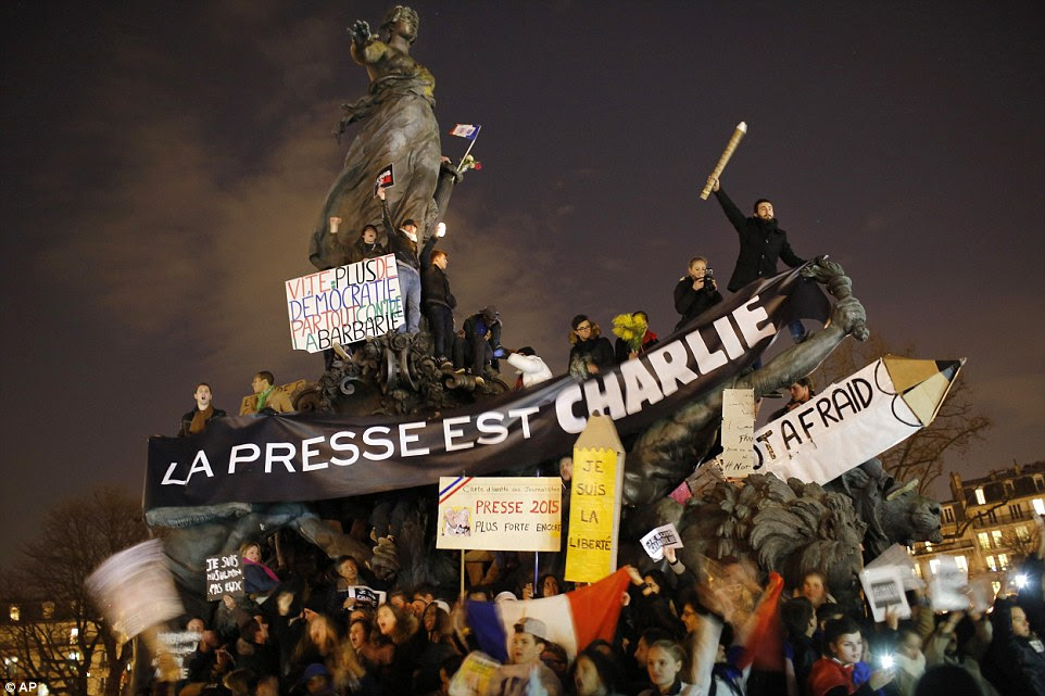 Journalists and protesters wave banners and signs in support of Charlie Hebdo, the satirical magazine which came under siege last week when terrorists stormed its office