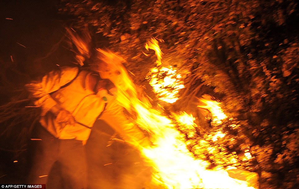 Ferocious: Flames leap as a firefighter attempts to put out the fire