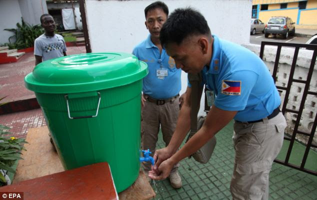 United Nations workers from the Philippines wash their hands to avoid contact with the virus in Liberia