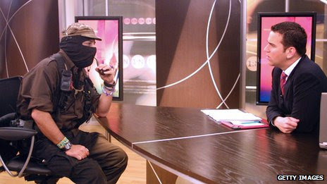 Subcomandante Marcos (left) is interviewed by journalist Carlos Loret de Mola on Televisa on 9 May, 2006