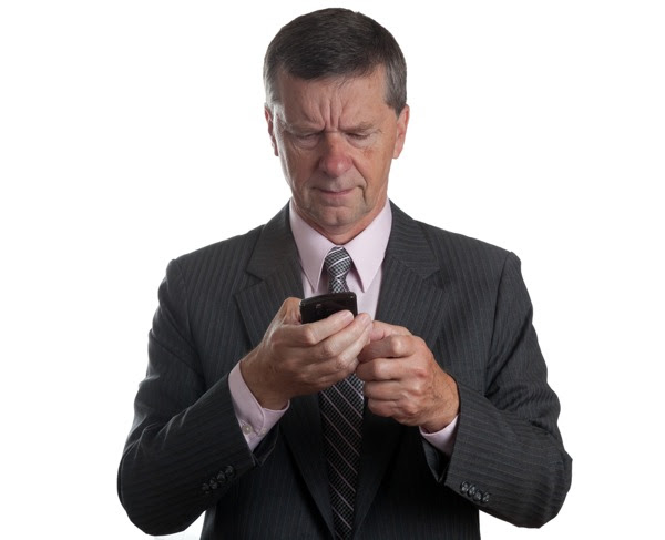 Businessman scowls at blackberry (Steve Heap/Shutterstock)