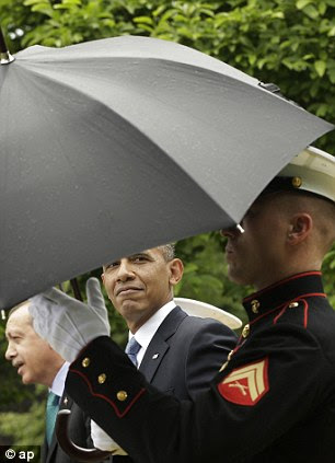 Rule Breaker: President Barack Obama, center, watches a Marine remove the umbrella after it stopped raining during his joint news conference with Turkish Prime Minister Recep Tayyip Erdogan