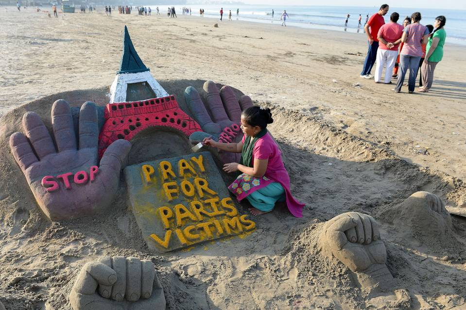 Indian sand artist Laxmi Gaud, on a beach in Mumbai, works on a sculpture paying tribute to the victims of the Nov. 13 attacks in Paris.