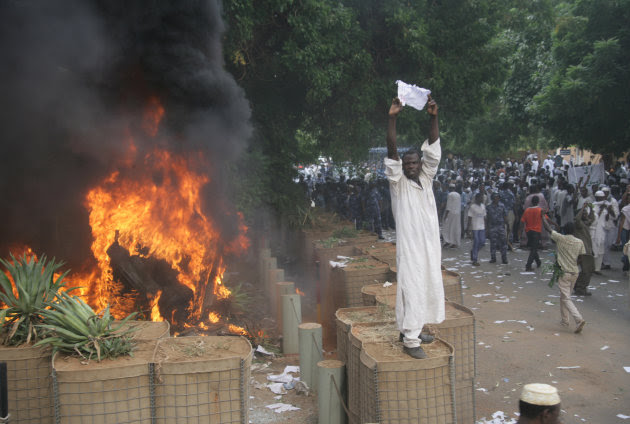 A Sudanese protester stands on a barricade during a demonstration in Khartoum, Sudan, Friday, Sept. 14, 2012, as part of widespread anger across the Muslim world about a film ridiculing Islam's Prophet Muhammad. Germany's Foreign Minister says the country's embassy in the Sudanese capital of Khartoum has been stormed by protesters and set partially on fire. Minister Guido Westerwelle told reporters that the demonstrators are apparently protesting against an anti-Islam film produced in the United States that denigrates the Prophet Muhammad.(AP Photo/Abd Raouf)