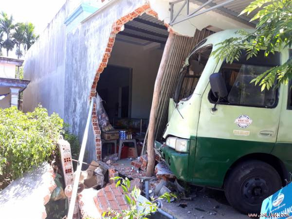  Đầu xe buýt nằm trong cửa nhà dân sau khi bị xe tải tông vào đuôi, đẩy tới.