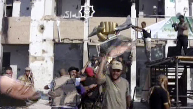 Rebeldes celebram após invadirem a fortaleza de Muammar Kadhafi em Trípoli, capital da Líbia, nesta terça-feira (23) (Foto: AP)