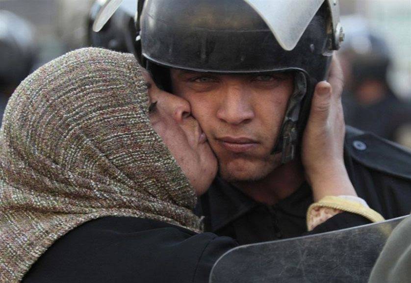 Mulher egípcia beija um policial durante a revolução contra o governo Mubarak no Egito, 2011